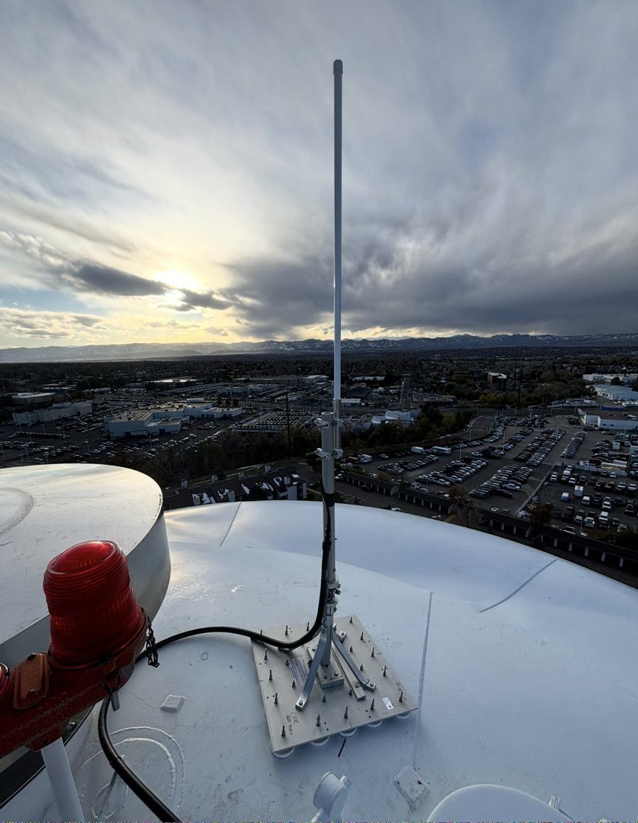 AMI collector antenna mounted on the roof of an elevated water tank above a city at sunset