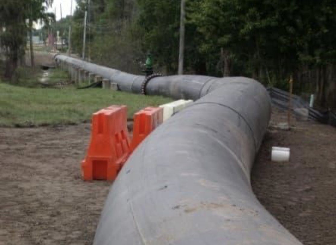 Above-ground HDPE pipe run beside a road